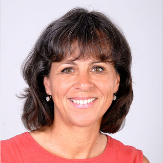 Portrait einer Frau mit dunklen, schulterlangen Haaren und Lächeln.